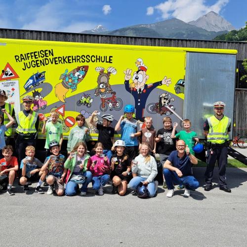 Die Kinder mit dem neu erhaltenen Fahrradführerschein vor dem Verkehrserziehungsbus.