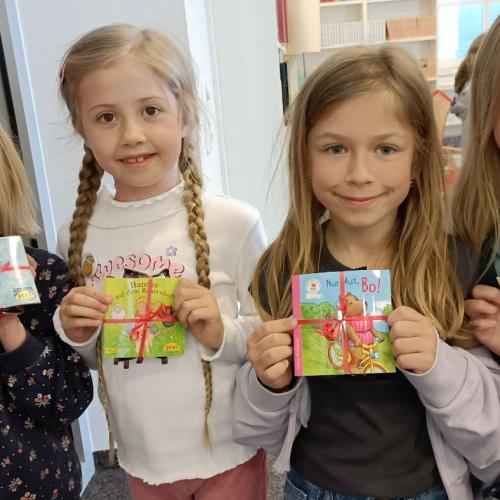 Vier Kinder mit einem kleinen Buch als Geschenk der Stadtbücherei Lienz