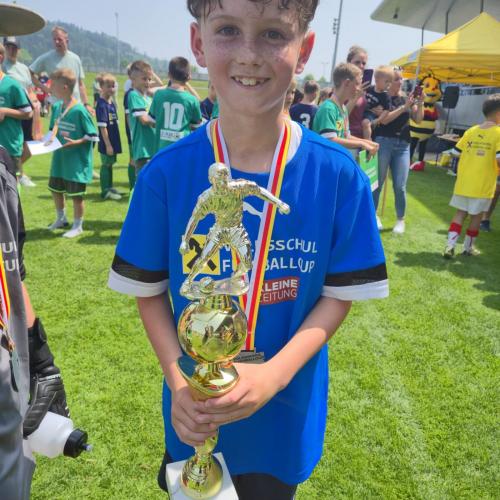 Ein siegreicher Fußballer mit seiner Trophäe.