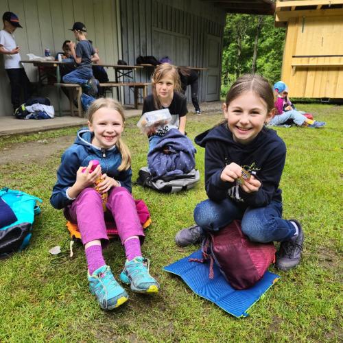 Einige Kinder sitzen im Gras.