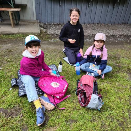 Einige Kinder sitzen im Gras.
