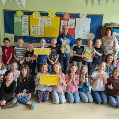 Klassenfoto der 3b mit dem Imker Karl und Bienenwaben.