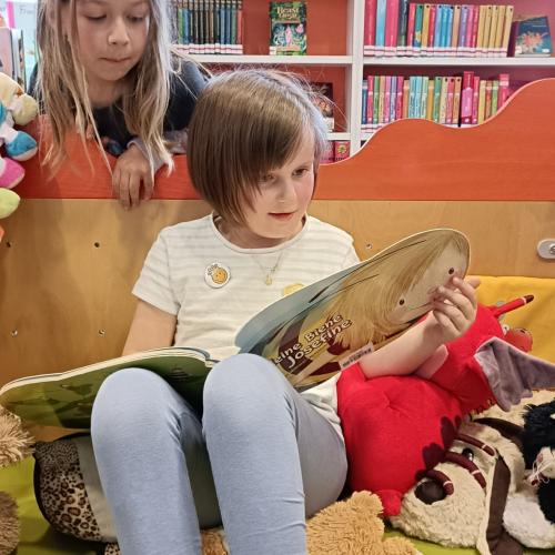 Kinder schmökern in Büchern in der Stadtbücherei Lienz.