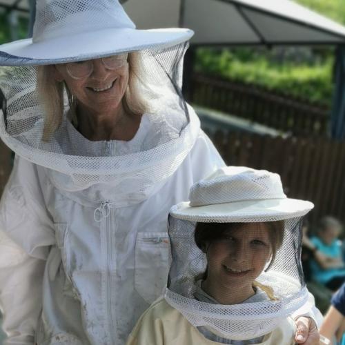 Kind und Imkerin in der Imkerkleidung