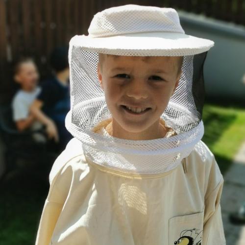 Kind in der Imkerkleidung