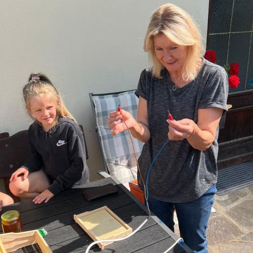 Imkerin zeigt die Gitterrahmen mit Wachs