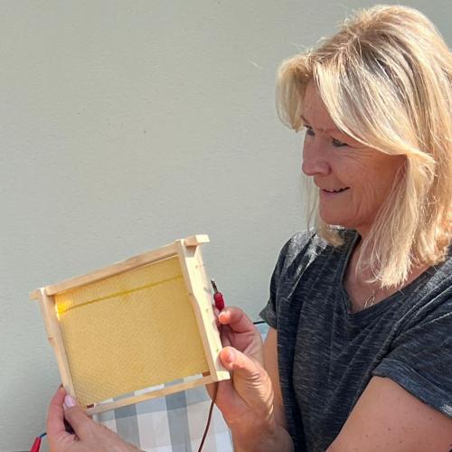 Imkerin zeigt die Gitterrahmen mit Wachs