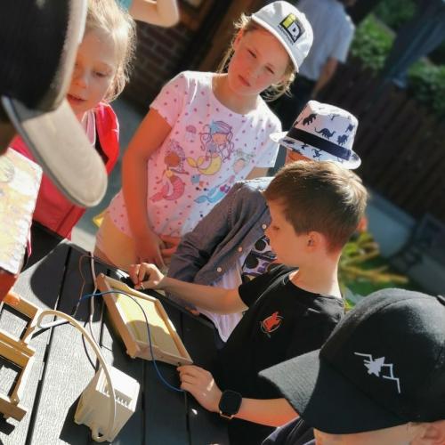 Kind spannt Drähte im Gitterrahmen für Bienen
