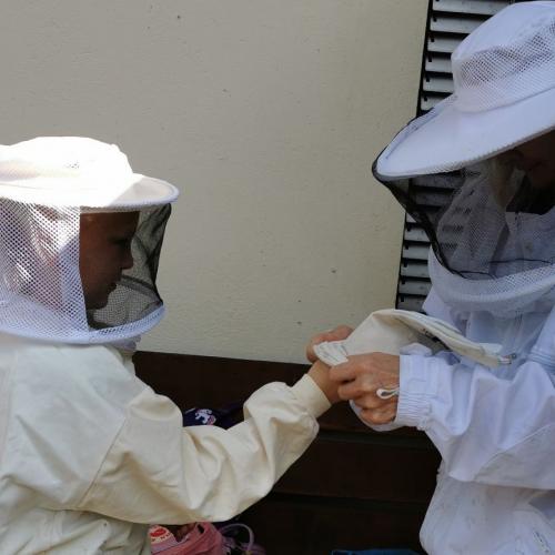 Kind und Imkerin in der Imkerkleidung