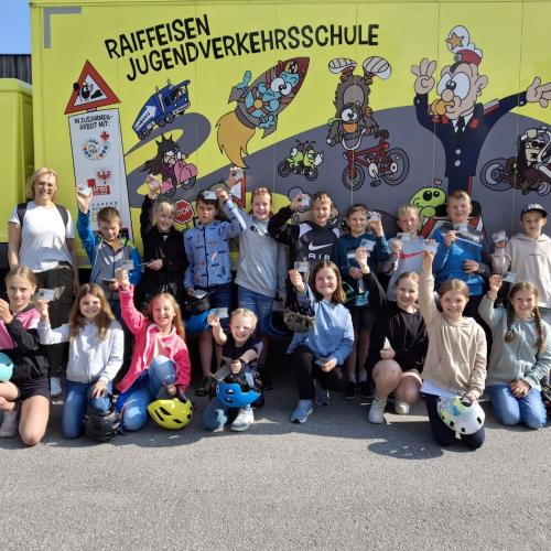 Die 4a Klasse steht vor dem Verkehrserziehungsbus und freut sich über die bestandene Fahrradprüfung.