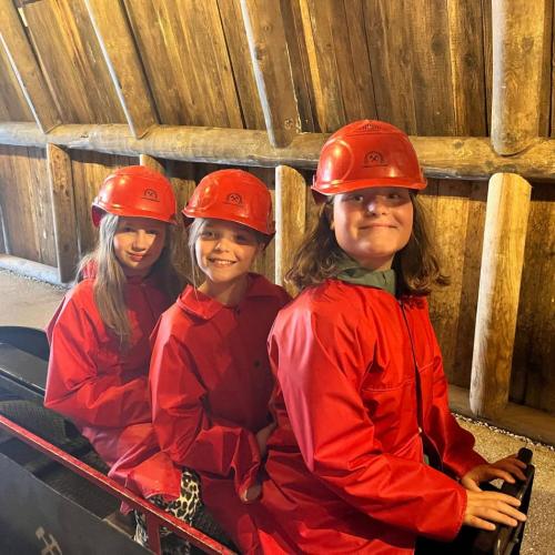 Drei Kinder sitzen auf der kleinen Bahn ins Schwazer Silberbergwerk.