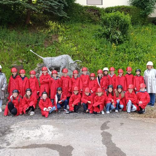 Eine vierte Klasse steht in Schutzkleidung vor dem Schwazer Silberbergwerk.
