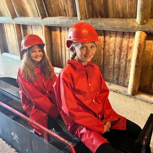 Zwei Kinder sitzen auf der kleinen Bahn ins Schwazer Silberbergwerk.