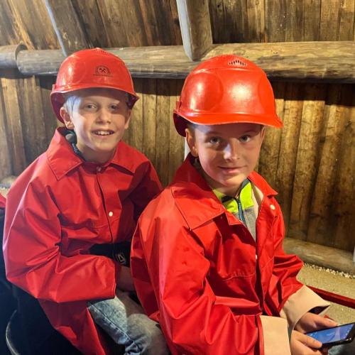 Zwei Kinder sitzen auf der kleinen Bahn ins Schwazer Silberbergwerk.