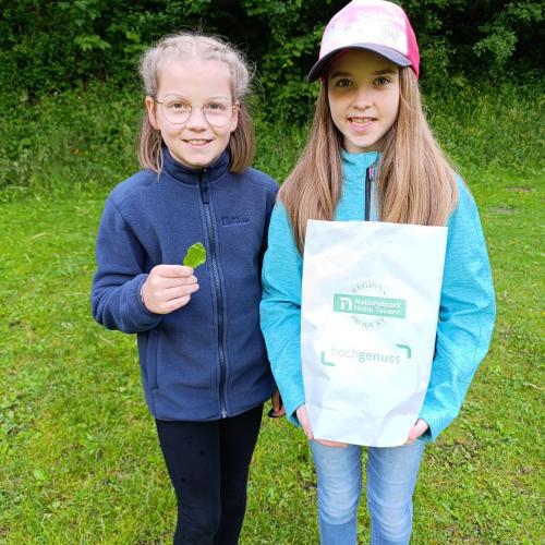 Kinder zeigen ihre gefundenen Kräuter.