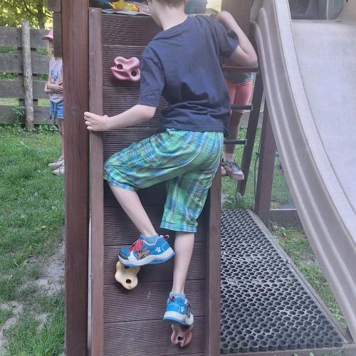 Kind klettert auf Klettergestell