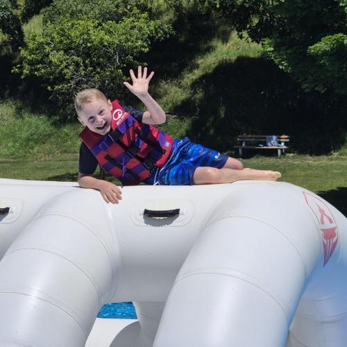 Kind auf der Hüpfburg im Wasser