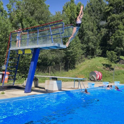 Kind springt vom Turm ins Wasser