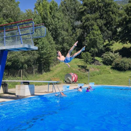 Kind springt vom Turm ins Wasser