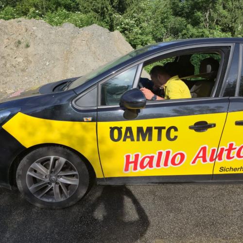 Ein ÖAMTC-Mitarbeiter zeigt den Kindern, wie lange der Bremsweg eines Autos bei trockner und nasser Fahrbahn ist.