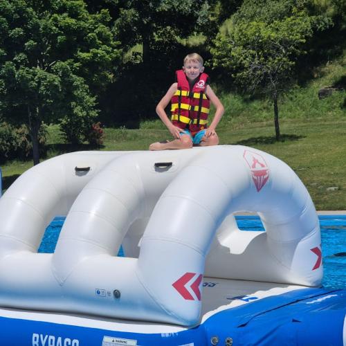 Kind auf der Hüpfburg im Wasser