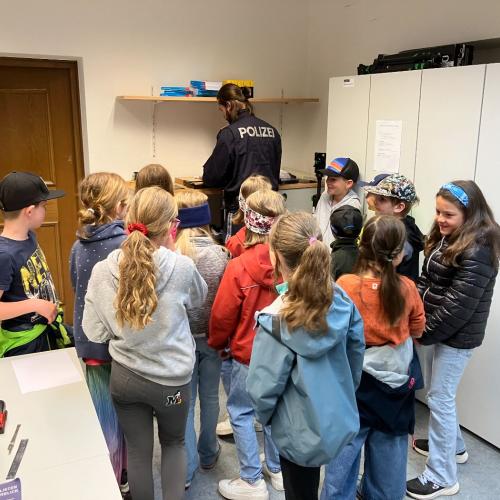Ein Polizist erklärt den Kindern die Polizeiarbeit.