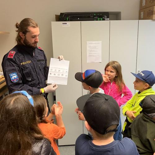 Ein Polizist erklärt den Kindern die Polizeiarbeit.