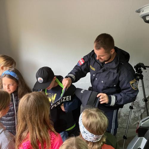 Ein Kind zieht eine Polizeiweste an.
