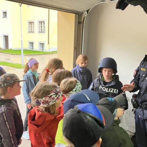 Ein Kind zieht eine Polizeiweste an.