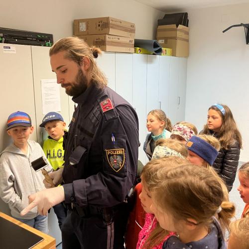 Ein Polizist zeigt den Kindern, wie man Fingerabdrücke nimmt.