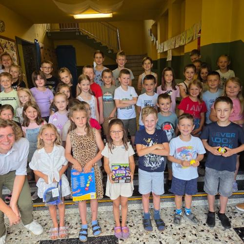 Gruppenfoto aller 1. Klassen mit den Sieger:innen des Zeichenwettbewerbs