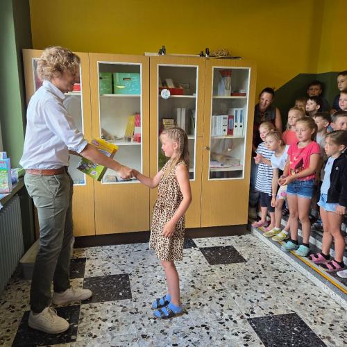 Den Siegern des Zeichenwettbewerbs wird von einem Raika- Mitarbeiter gratuliert.