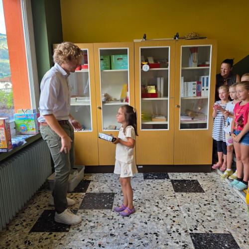 Den Siegern des Zeichenwettbewerbs wird von einem Raika- Mitarbeiter gratuliert.