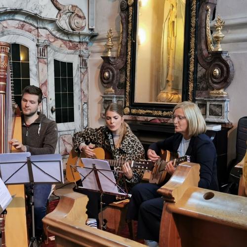 ein Harfespieler und zwei Gitarristinnen bei der Eröffnungsmesse in der Kirche