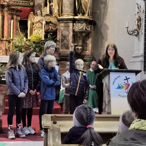 Eine Lehrerin liest eine Geschichte vor und fünf Kinder spielen die Geschichte nach.