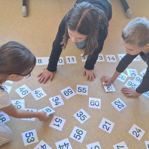 Kinder ordnen Zahlenkärtchen von 1 bis 60