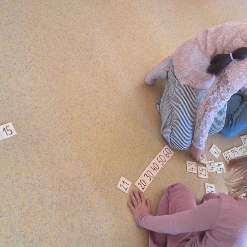 Kinder ordnen Zahlenkärtchen von 1 bis 60