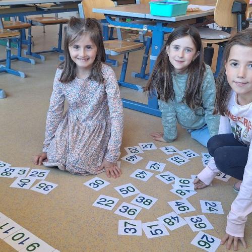 Kinder ordnen Zahlenkärtchen von 1 bis 60
