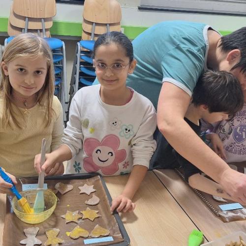 Kinder bestreichen Kekse mit Eigelb.