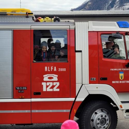 Feuerwehrauto, aus dem Kinder winken
