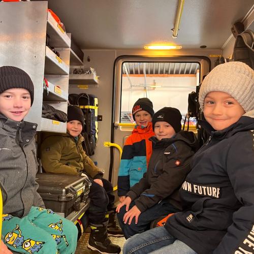 Die Kinder dürfen im Feuerwehrauto mitfahren.