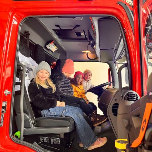 Die Kinder dürfen im Feuerwehrauto mitfahren.