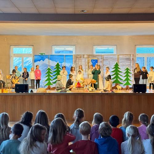 Kinder spielen ein Weihnachtsstück auf der Bühne.