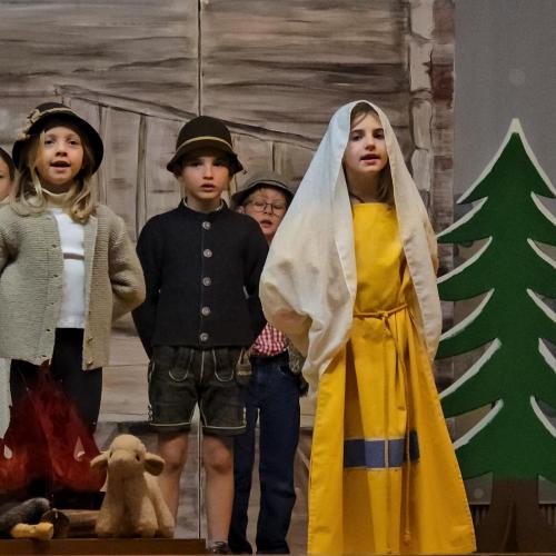 Kinder spielen ein Weihnachtsstück auf der Bühne.