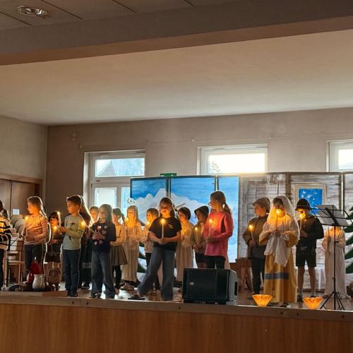 Kinder spielen ein Weihnachtsstück auf der Bühne.