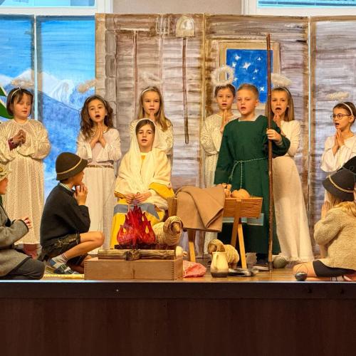 Kinder spielen ein Weihnachtsstück auf der Bühne.