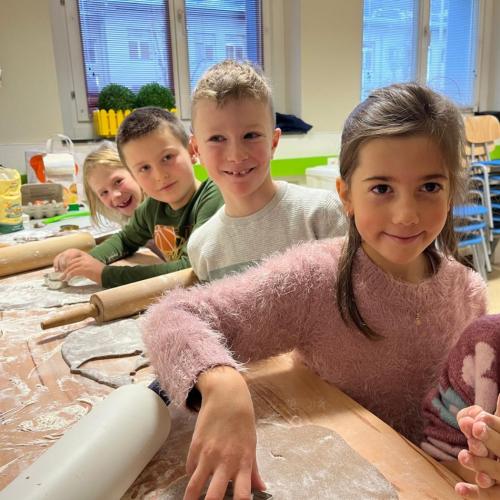 Kinder rollen Keksteig aus