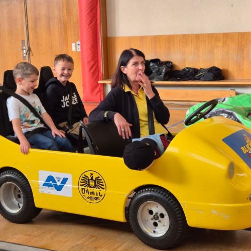 Kinder werden im Blick und Klick - Auto durch den Turnsaal kutschiert.