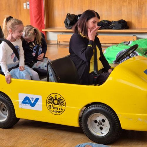 Kinder werden im Blick und Klick - Auto durch den Turnsaal kutschiert.