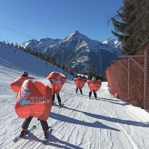 Kinder mit den Schikursflaggen als Flügel